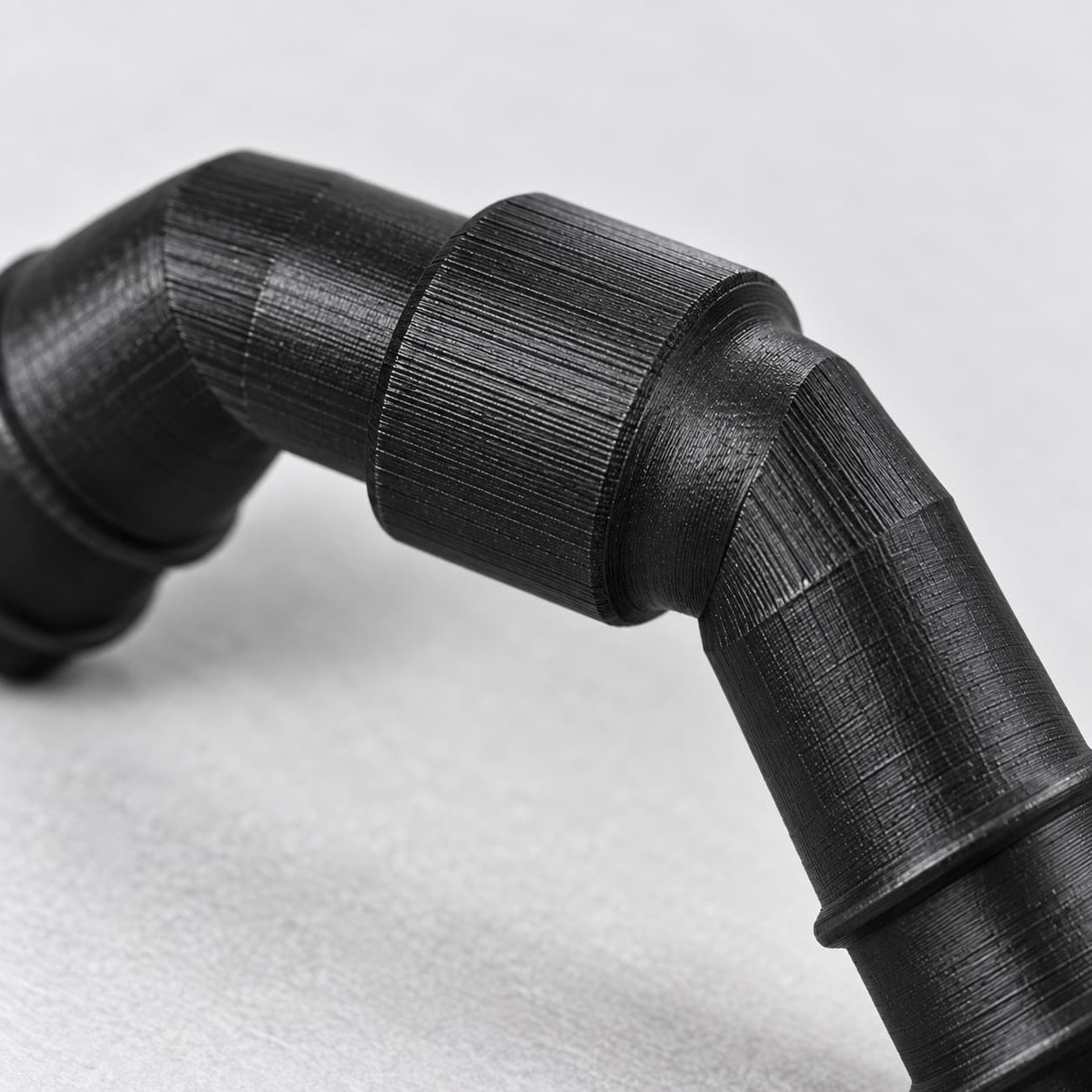Eheim 12/16mm to 3/4 Inch Vinyl Barb Elbow Adapter, 90 Degree, Black, close up of the printed surface