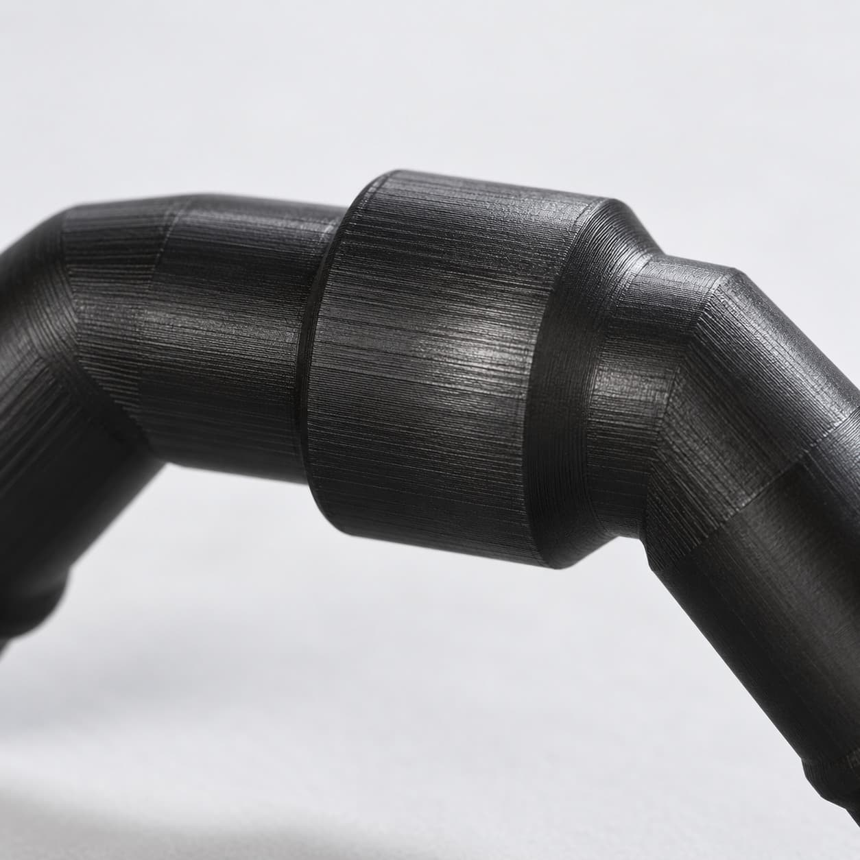 Eheim 12/16mm to 5/8 Inch Vinyl Barb Elbow Adapter, 90 Degree, Black, close up of the printed surface