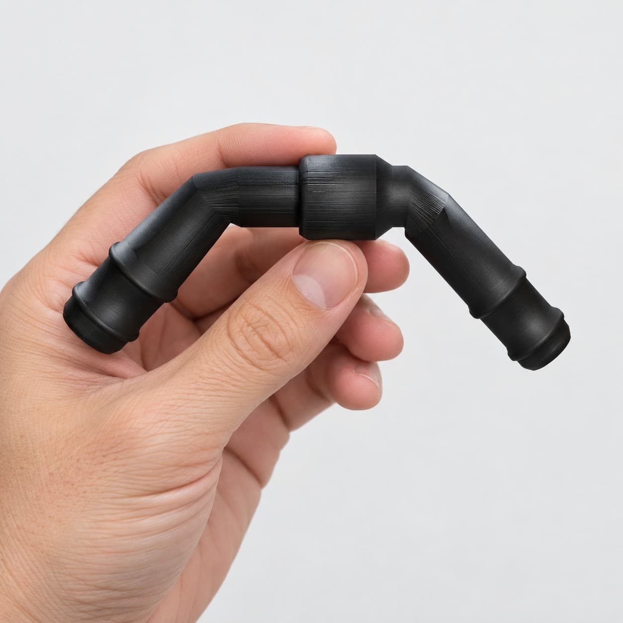 Eheim 12/16mm to 5/8 Inch Vinyl Barb Elbow Adapter, 90 Degree, Black, held in a hand to show its size