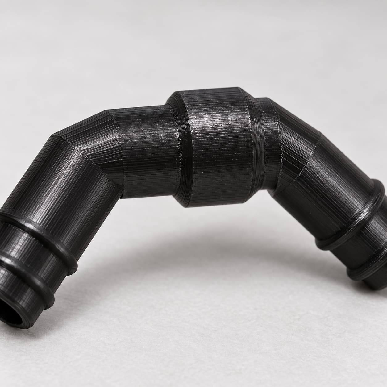 Eheim 16/22mm to 5/8 Inch Vinyl Barb Elbow Adapter, 90 Degree, Black, close up of the printed surface